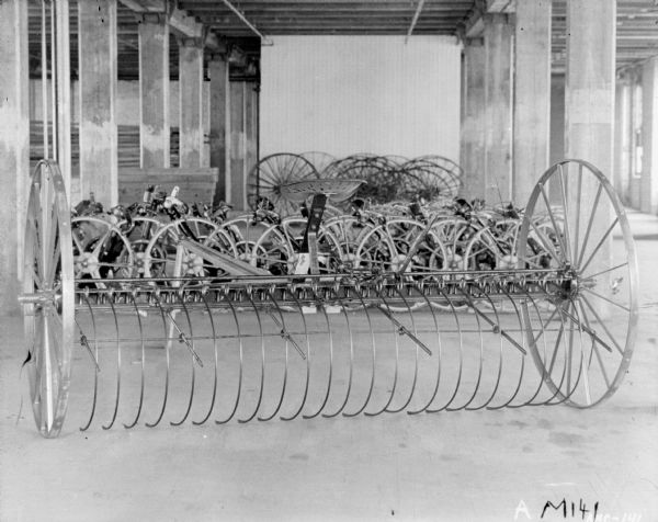 Dump rakes on factory floor at McCormick Works. Wheels are stored in the background.