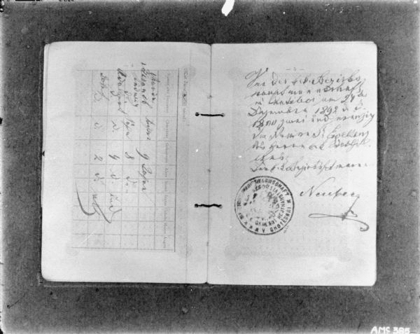 Inside pages of a tattered bound document written in German, with handwritten notes filling in blanks on the left page, and handwriting near a stamp on the right page.