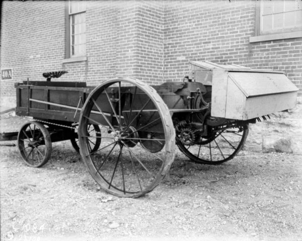 Manure spreader outdoors near a factory building.
