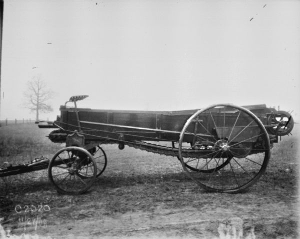 Side view of a manure spreader in a field.