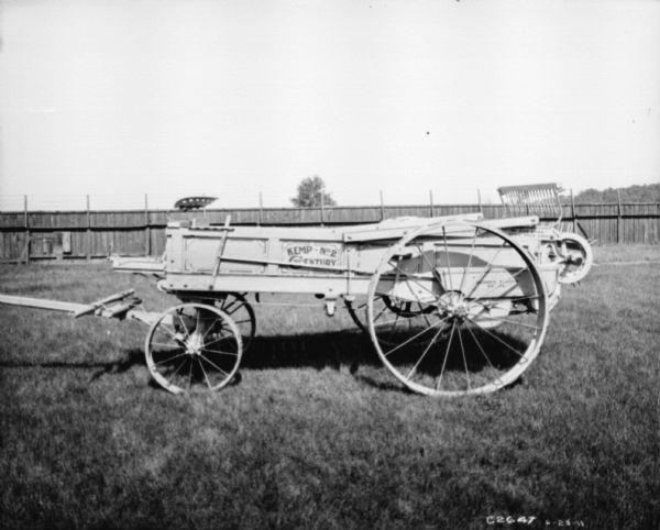 Left side view of a Kemp Manure Spreader #2 20th Century in a fenced-in yard at Springfield Works.