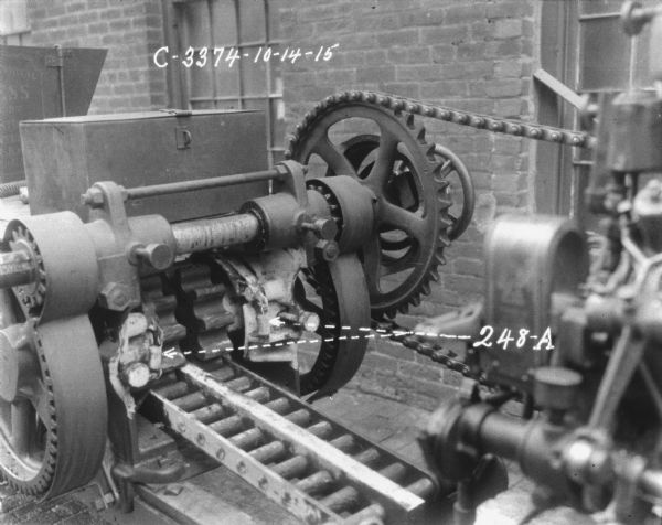 Close-up of hay press. Parts are labeled with "248-A" and two arrows pointing to springs on the machine.