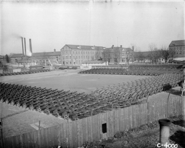 Elevated view of hundreds of hay presses lined up in a yard at Champion Works.