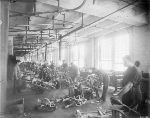 Interior view of men working with machines in a factory.