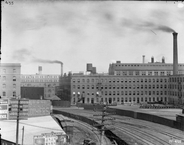Elevated view of McCormick Works. Advertisement are painted on the sides of a building on the left, and on the bottom left are billboards.