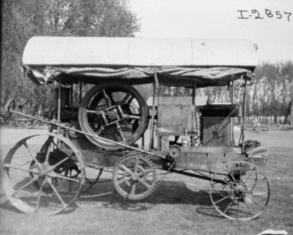 Side view of an early tractor parked outdoors.