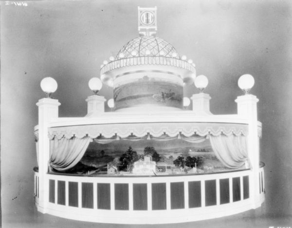 Exposition display with lights and a dome. The IHC logo is at the top of the dome. Includes a farm scene inside the circular display.