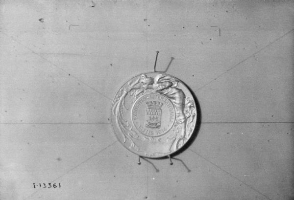 Commemorative coin pinned to a board.