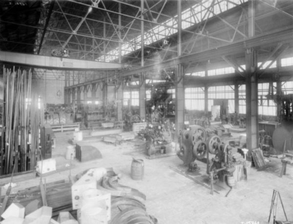 Slightly elevated view of factory floor at McCormick Works. A crane is suspended over the floor on tracks in the center.