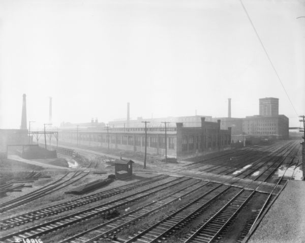Elevated view of railroad yard with factory buildings.