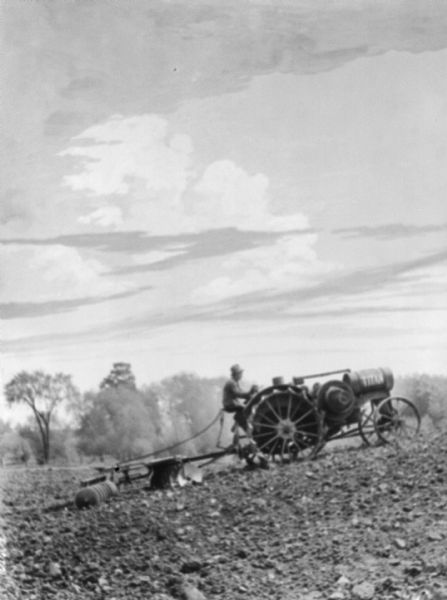 View across field towards a man driving a Titan tractor pulling a disk harrow in a field.