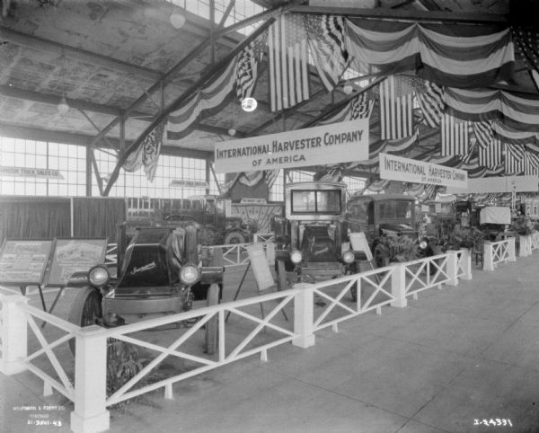 Display of trucks underneath banners and signs in a large building.