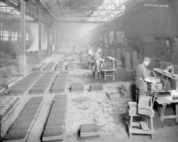 Elevated view of men working a manufacturing area of a factory.