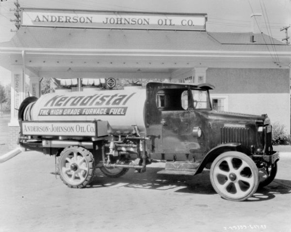 Right side view of an Anderson-Johnson Oil Co. delivery truck parked in front of the company building. Painted on the tank of the truck is a sign that reads: "Kerodistal, the High Grade Furnace Fuel."