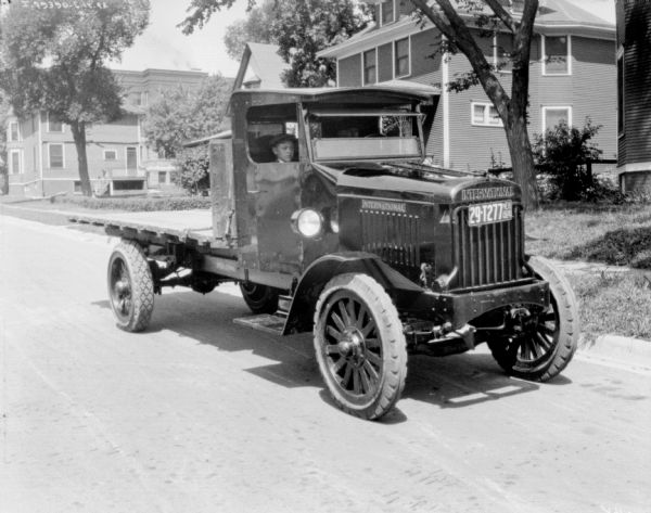 Three-quarter view from front right of a man in the driver's seat of a truck. A young boy is in the passenger street. The truck has a Nebraska license plate.