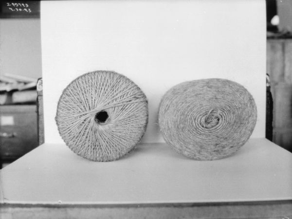 Close-up of two twine balls, each spooled differently. The twine is displayed on a white backdrop.