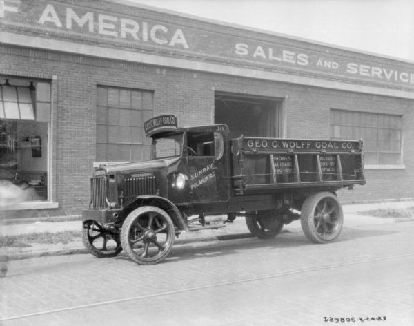 George C. Wolff Coal. Co. coal delivery truck parked in front of a brick building. A sign on the building reads, in part: "America, Sales and Service."