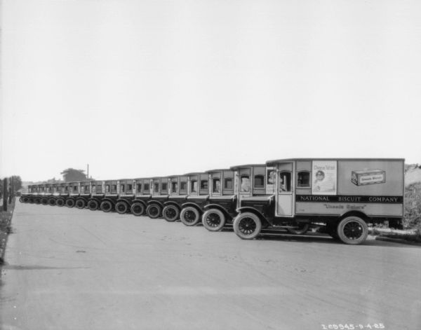 Fleet of Uneeda Biscuit delivery trucks of the National Biscuit Company parked close together at an angle.