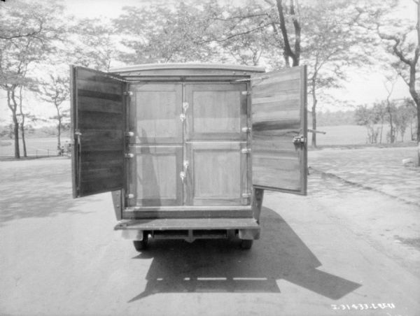 Rear view of a truck. There are four closed doors over the storage areas. There are two larger doors, also open, that when closed, would enclose the entire cabinet. 