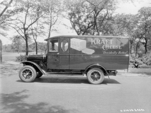Left side profile view of a delivery truck with an open door. The sign on the side of the truck reads: "Kraft Cheese 'Decidedly Better."