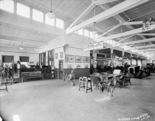 Product displays at a dealership. There are offices on the left, and a seating area in the foreground. There are clerestory windows above the exposed support beams.