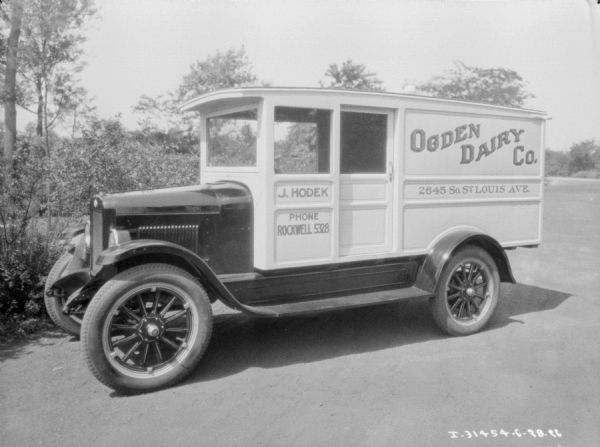 Left side view of a delivery truck for Ogden Dairy Co. parked outdoors.