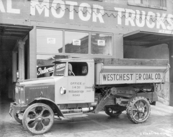 View of a truck for Westchester Coal Co. parked in front of a building with a sign that reads: "International Motor Trucks."