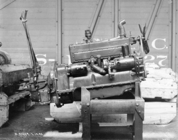 Dismantled engine showing parts. In the background is a railroad car.