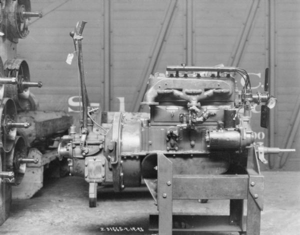 Dismantled engine showing parts. In the background is a railroad car.