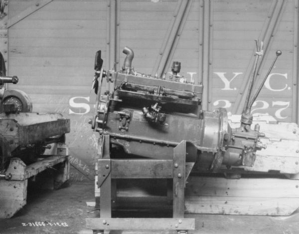 Dismantled engine showing parts. In the background is a railroad car.