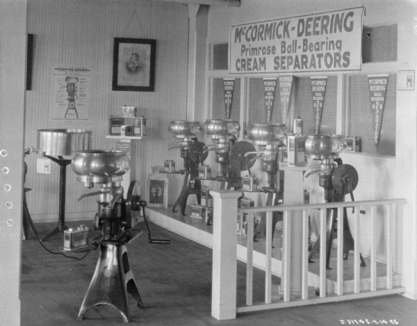 McCormick-Deering Primrose Ball-Bearing cream separators on display at a dealership. There is a portrait of Cyrus Hall McCormick on the wall.