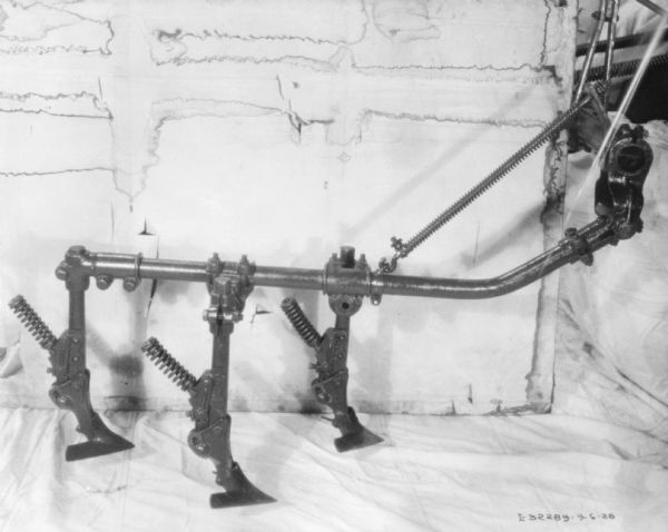 Section of cultivator, set up on a sheet on the floor, and against a white wall.
