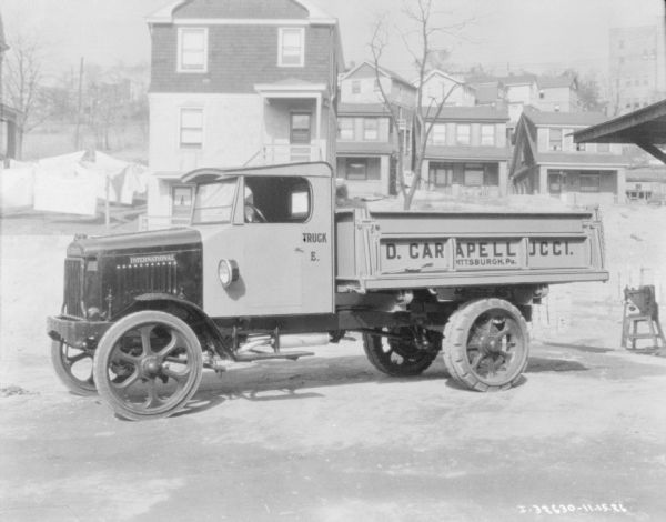 Delivery truck for D. Carapellucci parked outdoors. Houses are in the background.