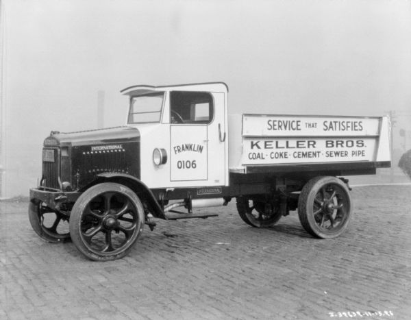 Keller Bros. coal, coke, cement and sewer pipe delivery truck parked outdoors.