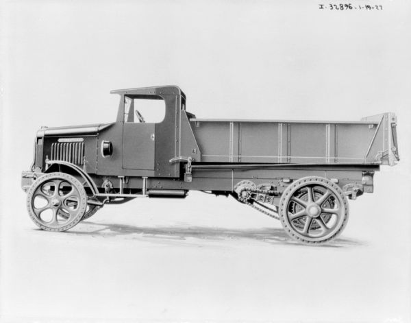 Left side profile view of a truck. There are chains attached to the rear wheel.