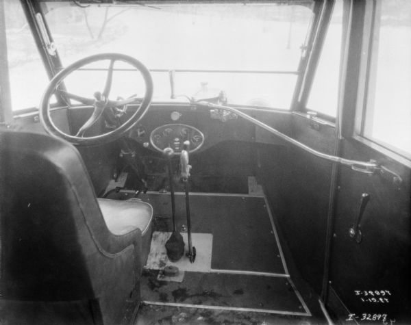 Interior view looking towards the driver's seat and steering wheel in the cab of an International truck.