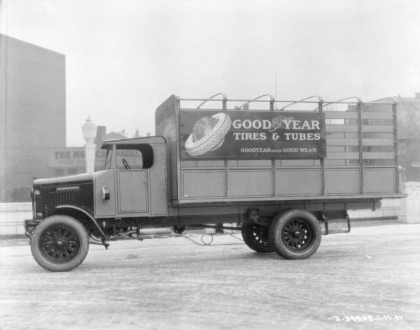 Driver's side view of delivery truck for Goodyear Tires & Tubes parked outdoors.