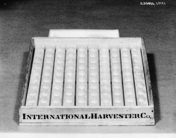 Close-up of a packing crate, with "International Harvester" stenciled on the front.