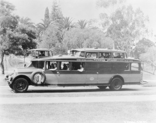 Left side view of a group of people riding in a large bus.