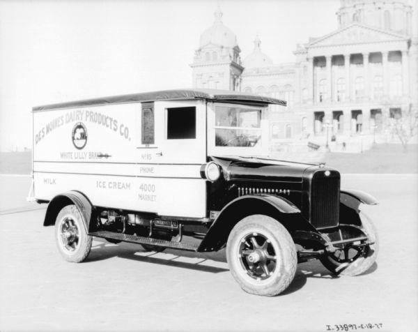 View of right side of the "Des Moines Dairy Products Co." delivery truck. In the background is the Iowa State Capitol building.