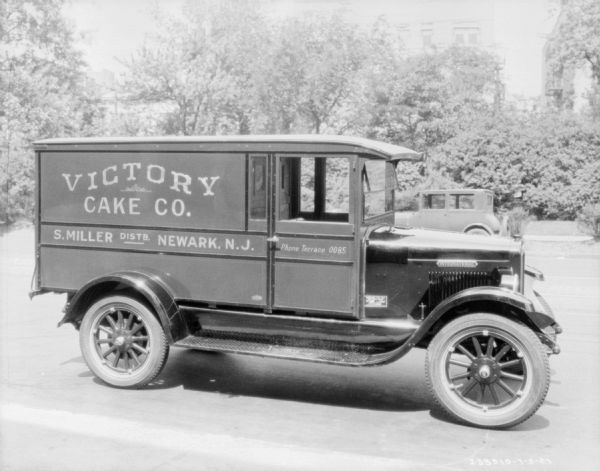 Right side view of truck parked on a road. The sign painted on the side  of the truck reads: "Victory Cake Co., S. Miller Distb. Newark, N.J."