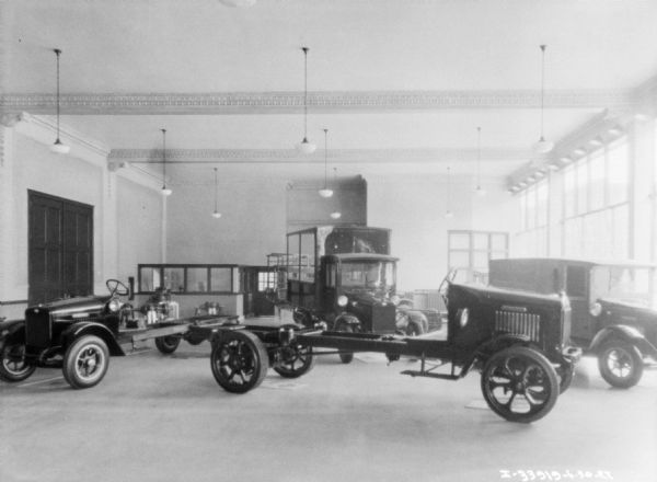 Trucks on display in the showroom of a dealership.