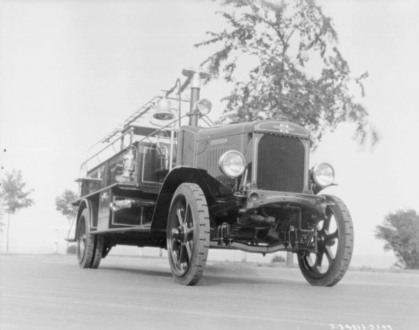Three-quarter view from front right of a Model 54-C 1927 fire truck parked outdoors on a street.