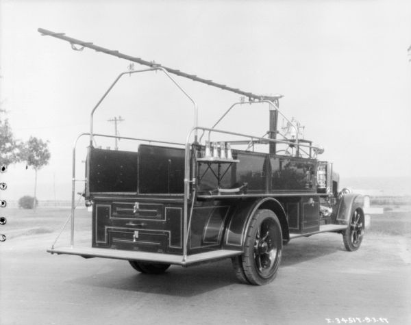 Three-quarter view from right rear of a Model 54-C 1927 fire truck parked in an open area. The sign painted on the side of the truck reads: "F.D.N.Y."