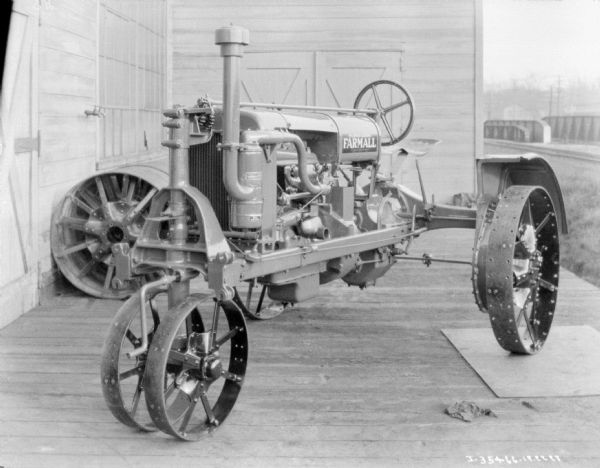 Three-quarter view from front right of a McCormick-Deering Farmall tractor parked on a loading dock.