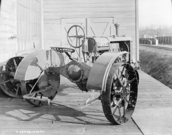 Three-quarter rear view from right of a McCormick-Deering Farmall tractor on a loading dock.