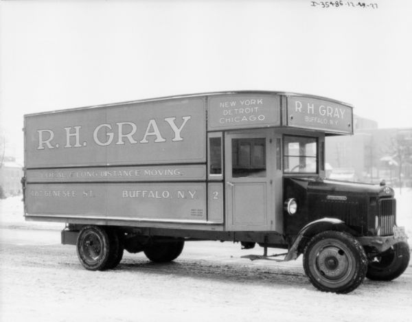 View across snowy street towards a parked moving van. The sign painted on the side of the truck reads: "R.H. Gray, Local & Long Distance Moving."