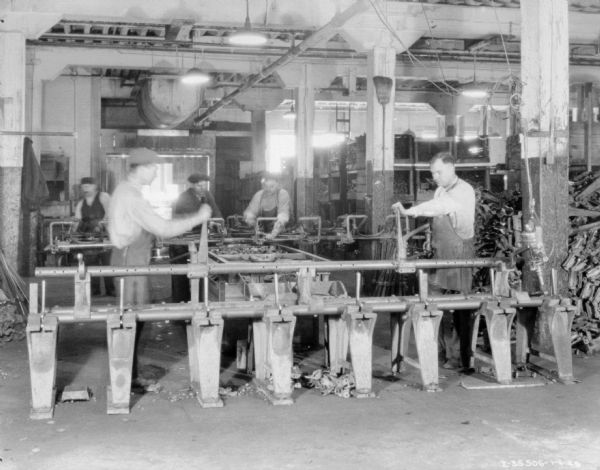 A group of men are working with machinery in a factory.