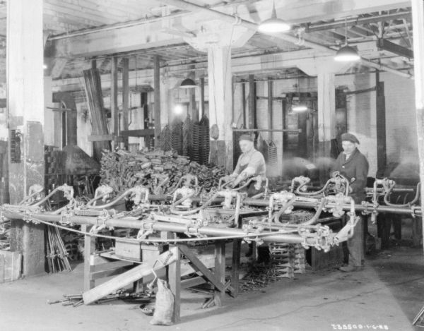 Men working in a factory, surrounded by parts.