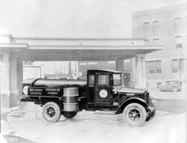 Standard Oil Company, Red Crown Gasoline truck parked at a service station. There may be an IH dealership across the street.